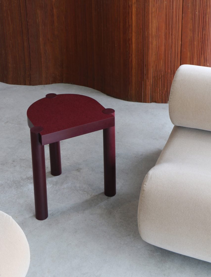 Burgundy-coloured three legged stool by Ebba Architects