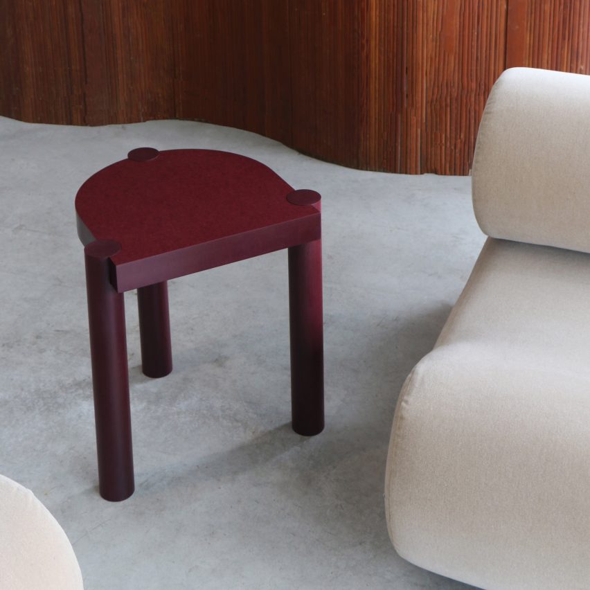 Burgundy-coloured three legged stool by Ebba Architects