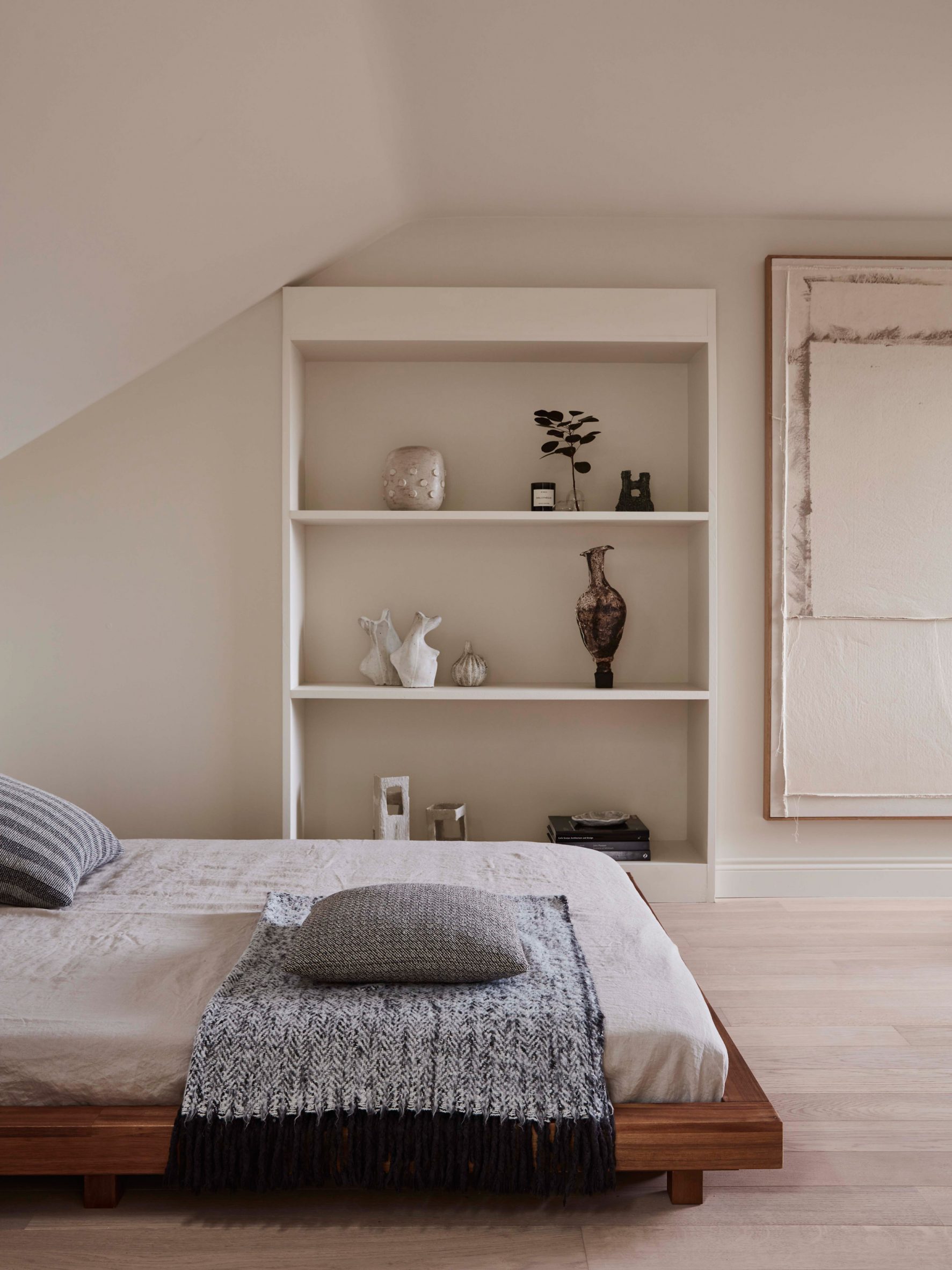 Bedroom interior by Daytrip with low timber bed and white shelving
