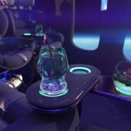 Rendering of glowing green cocktails sitting on the side table of a spacecraft lounge