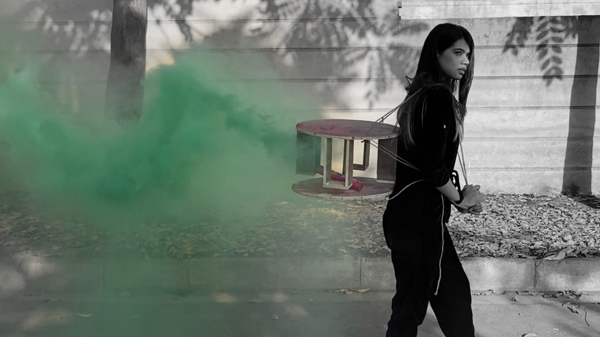 Black and white image of a girl with green smoke following by Interior Design MA at University of East London
