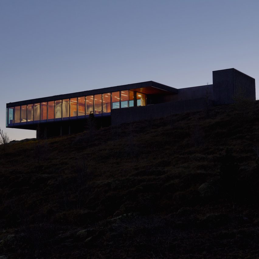 A photograph of the outside of Arborg House in Iceland, lit up in the dark