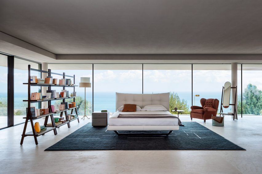 Aurora Tre bed on a rug in an open bedroom with floor to ceiling windows