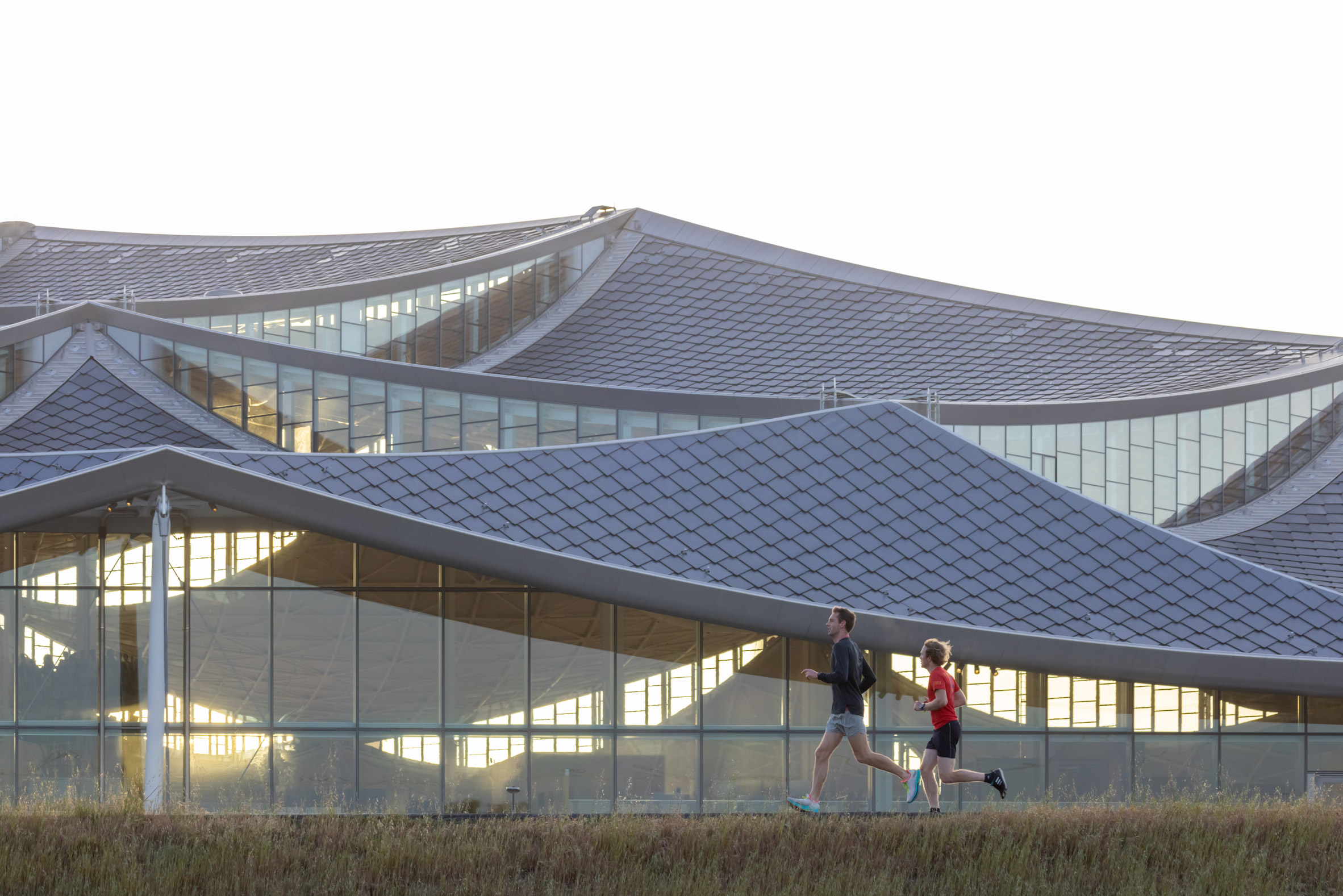 Image of people running past the tapered roof line at Bay View campus