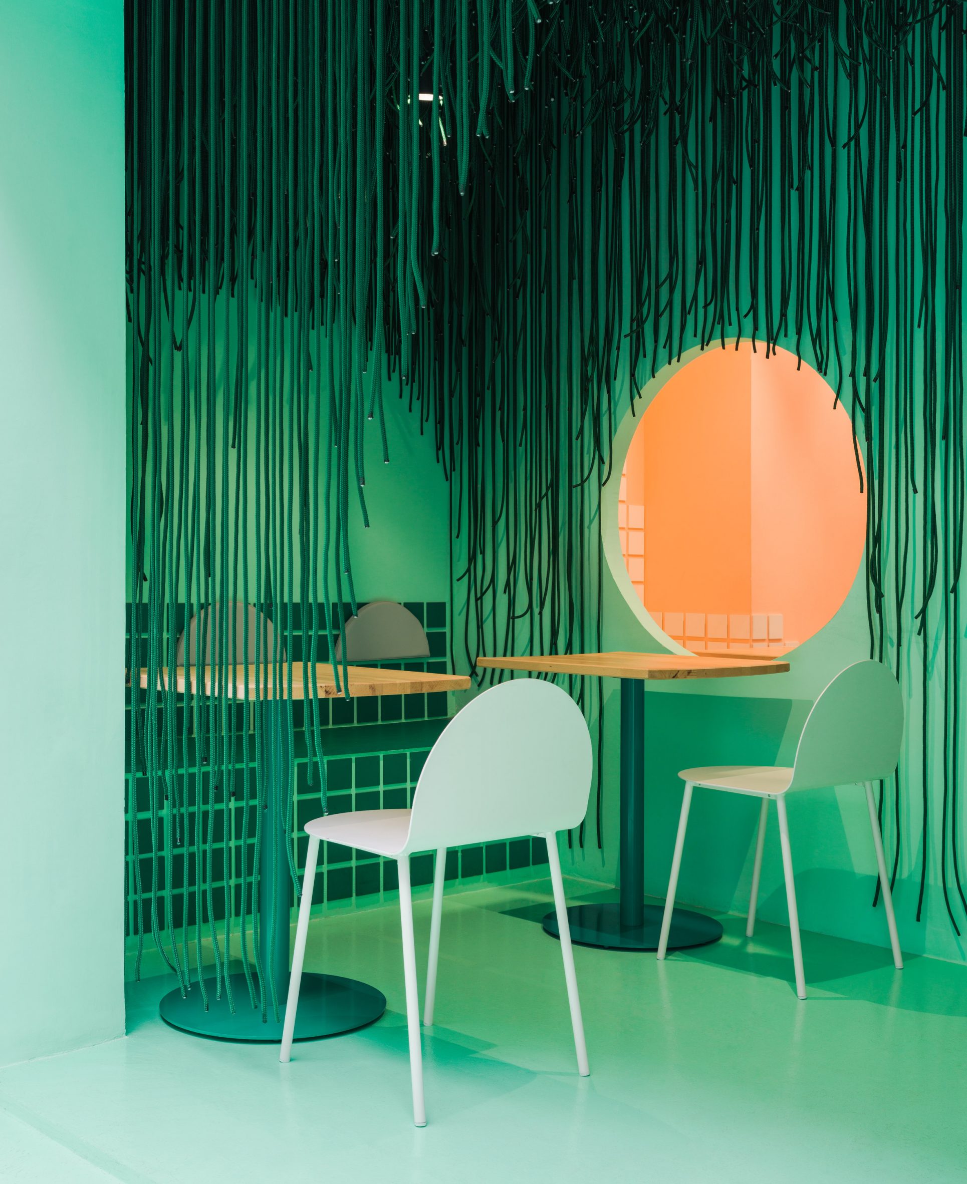 Porch with green chairs and suspended ropes in Baovan restaurant