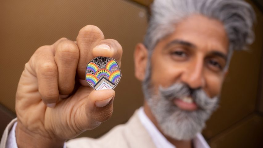 A man holding a coin celebrating 50 years of Pride