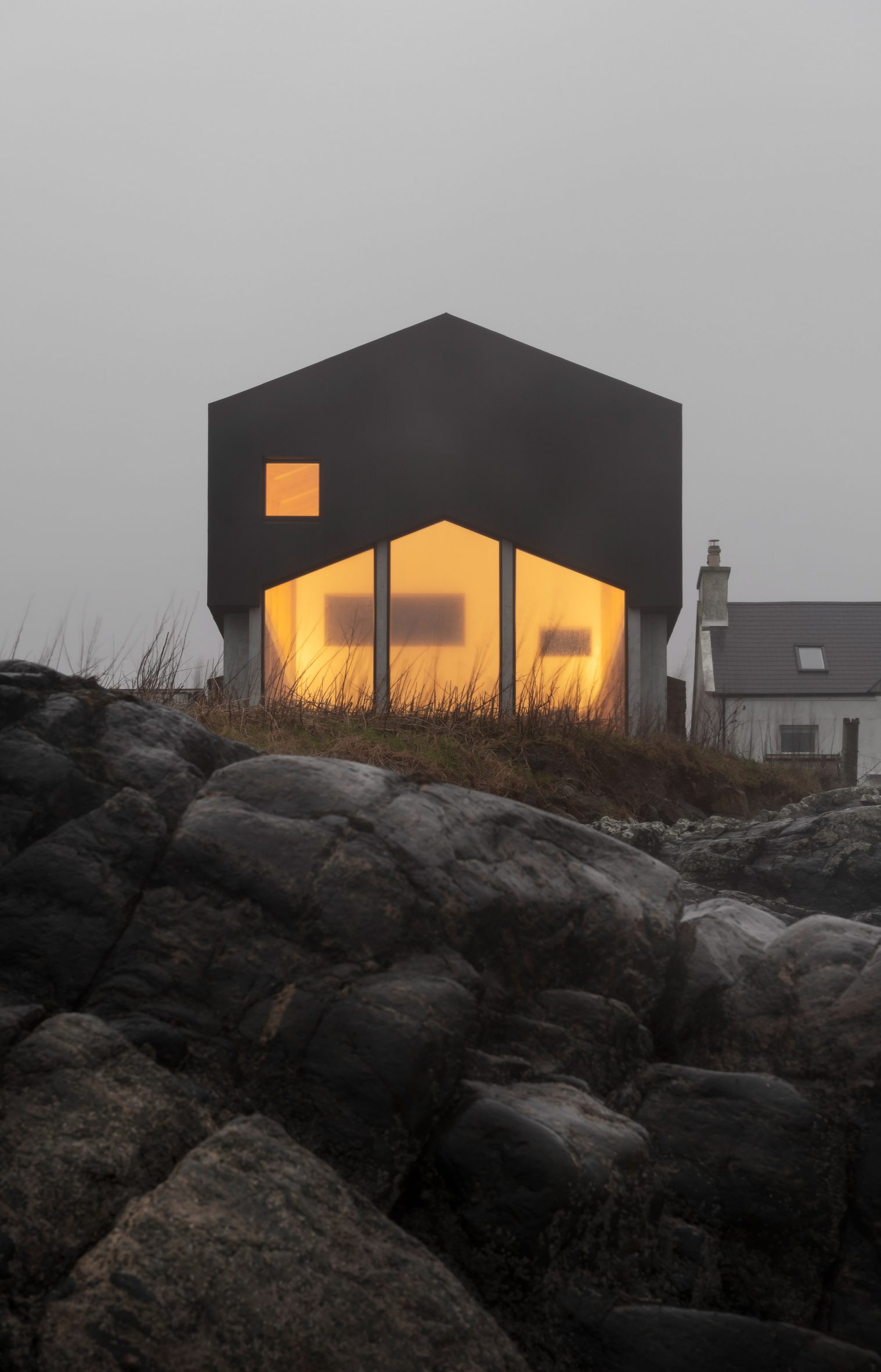 Mannal House has a gable end and is pictured lit at dusk