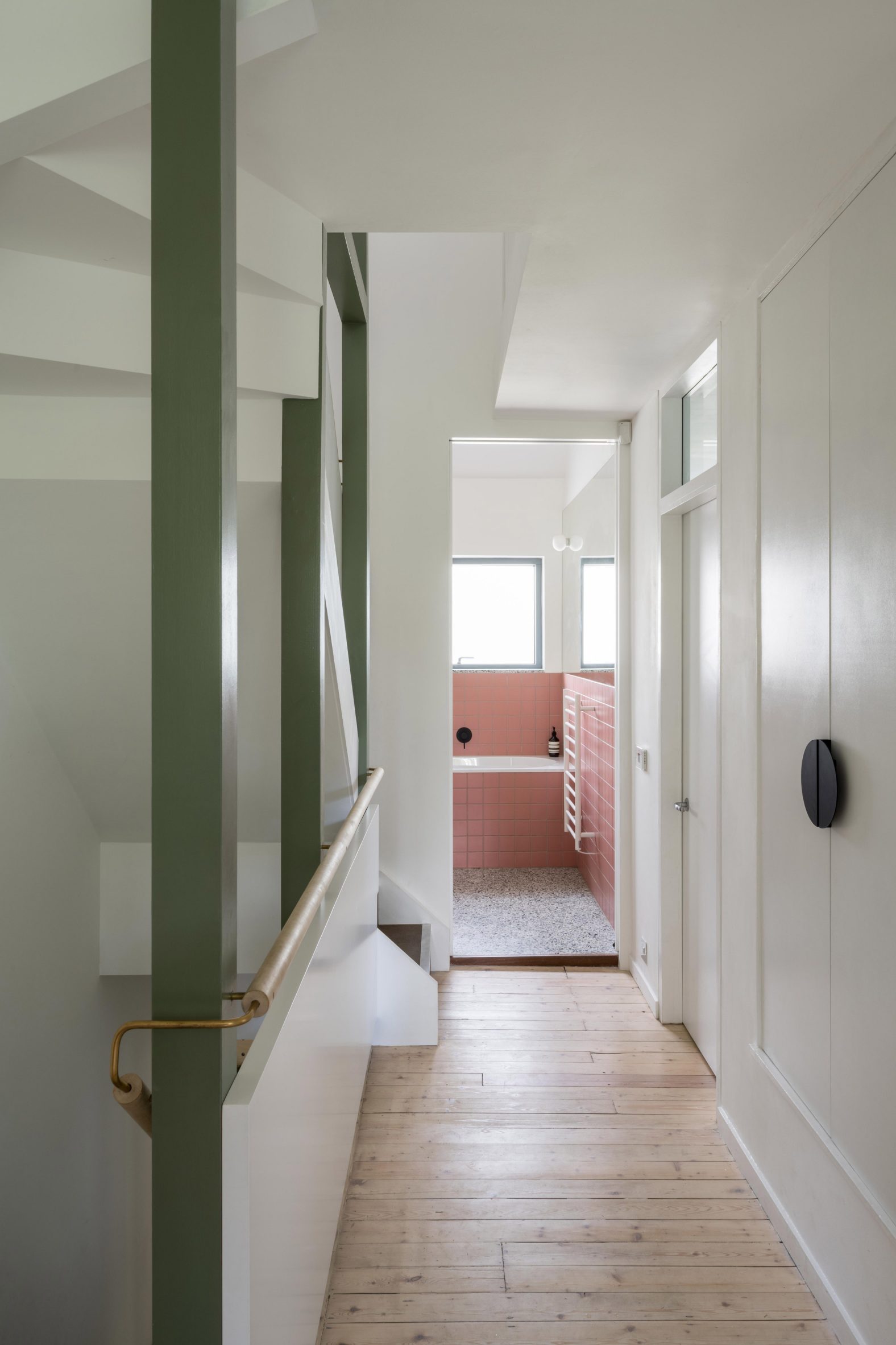 Interior image of a hallway that leads to a pink bathroom at Little Brownings
