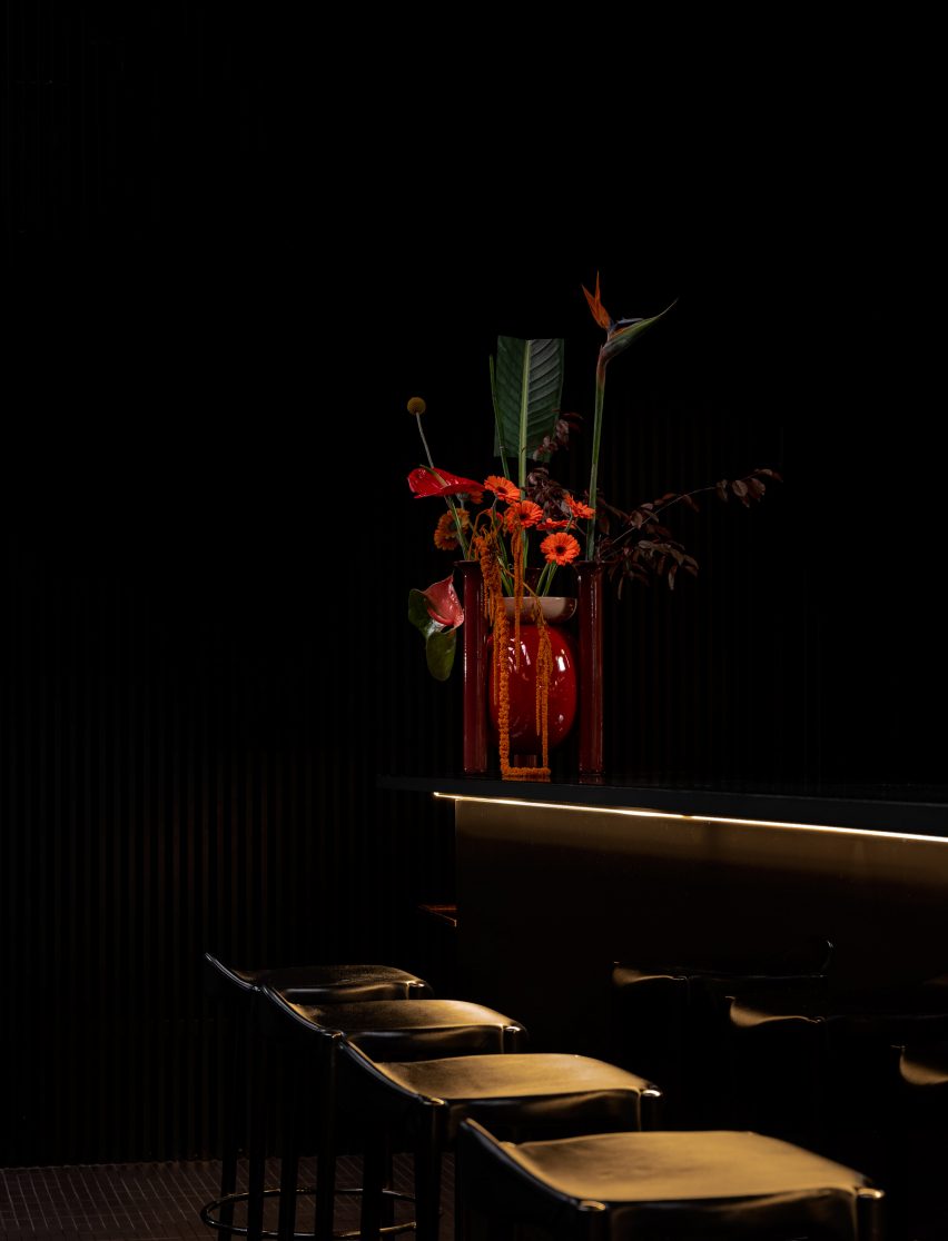 Red Explorer vase by BD Barcelona on a bar top in a dimly lit room