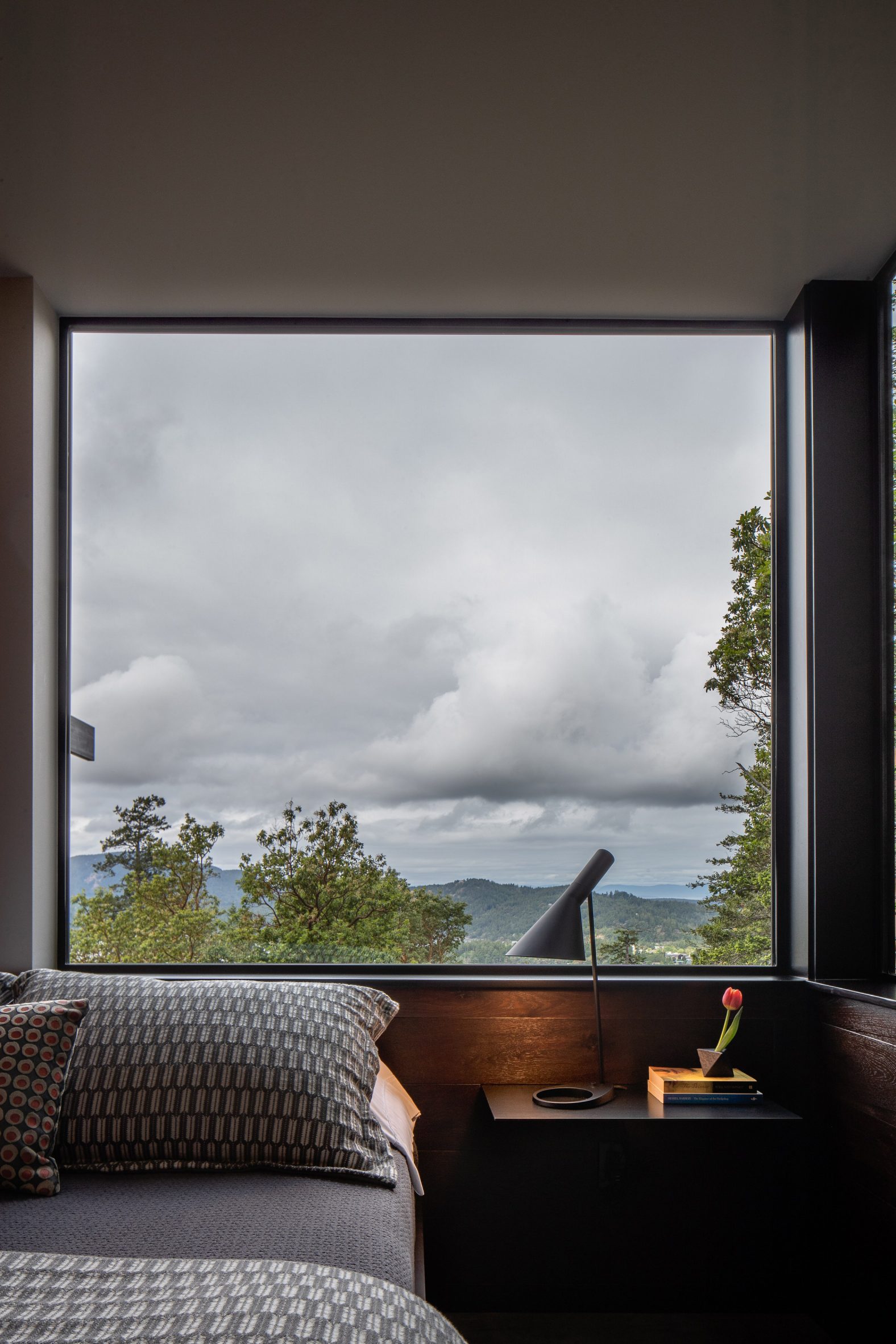A bed was set beneath a squared window at Buck Mountain Cabin