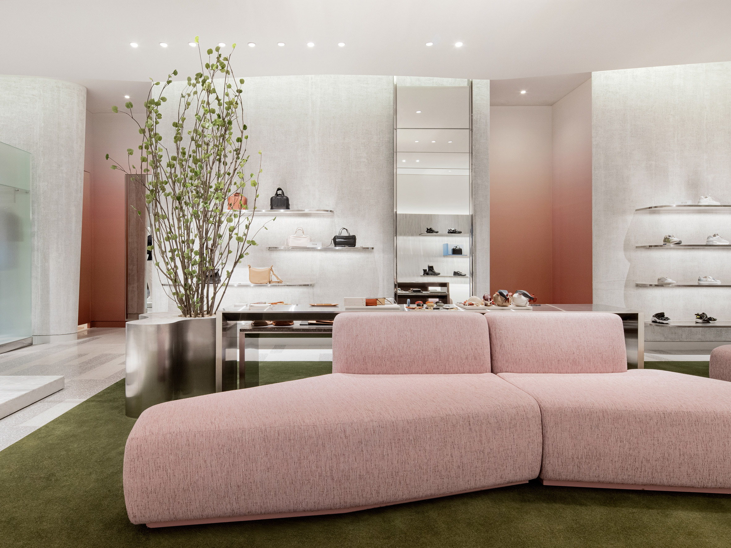 Seating area with green carpet and soft pink couch in Hyundai Seoul 