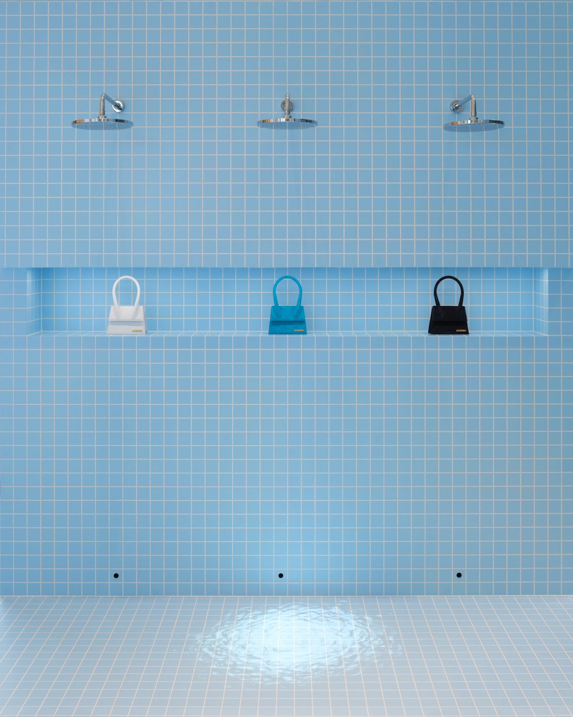 Image of a blue-tiled shower wall with Jacquemus bags at Le Bleu installation