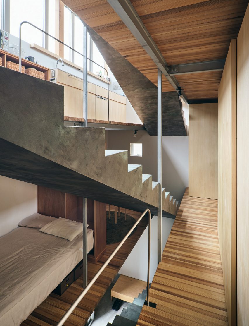A concrete staircase rises beside a sleeping area