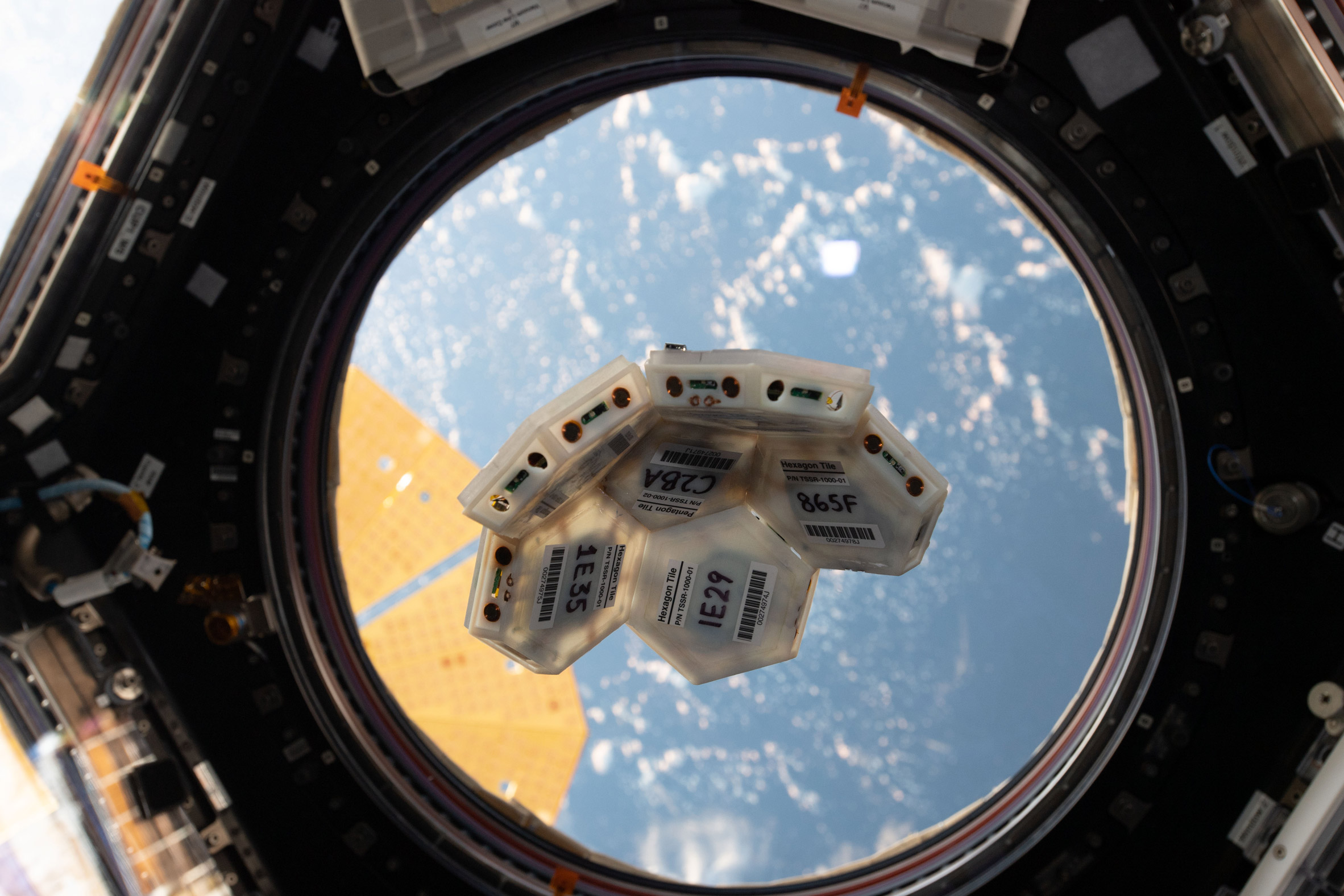 Tesserae tiles outside the window of a space station