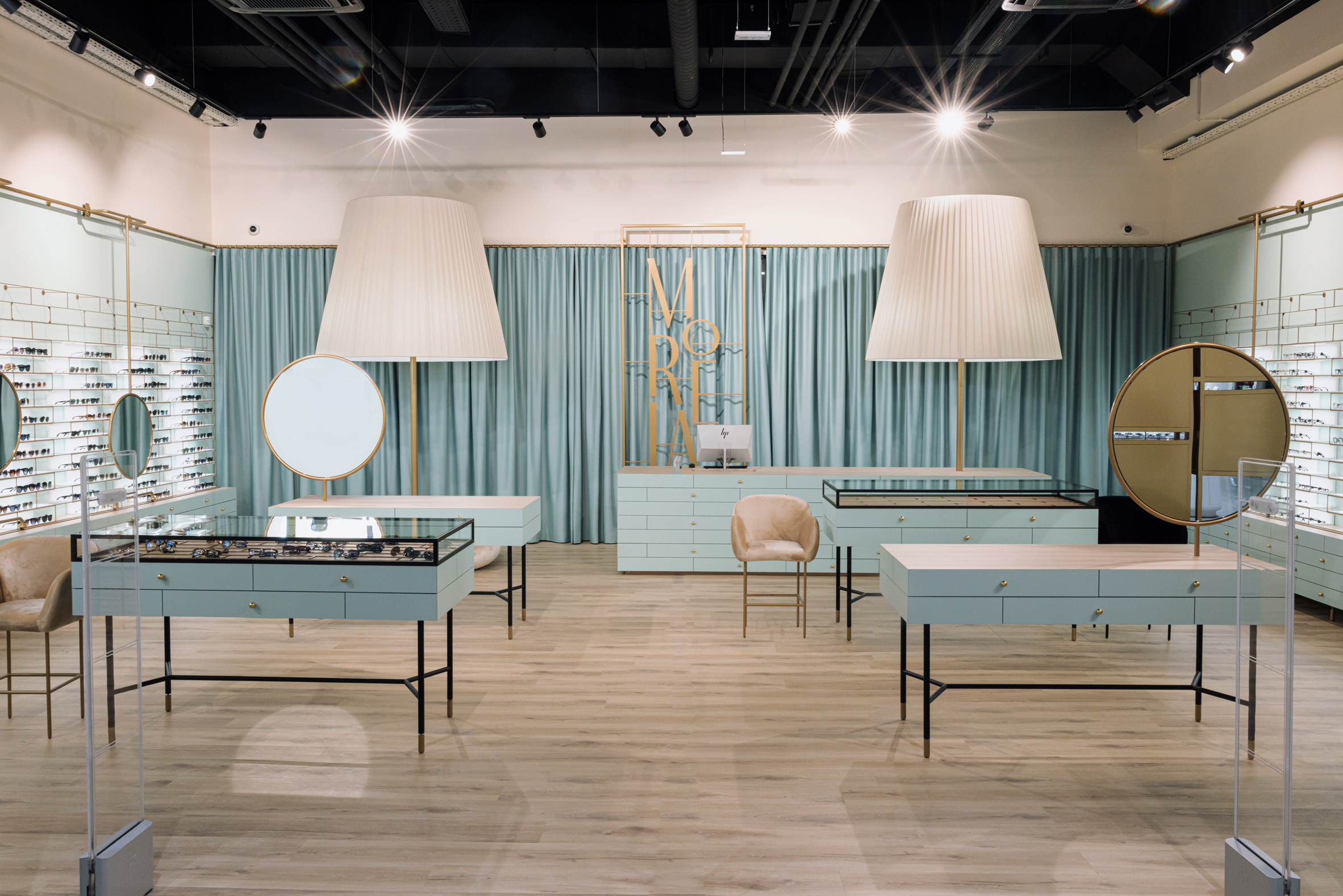 Overview of Morela eyewear store with two oversized lamps and powder-blue storage