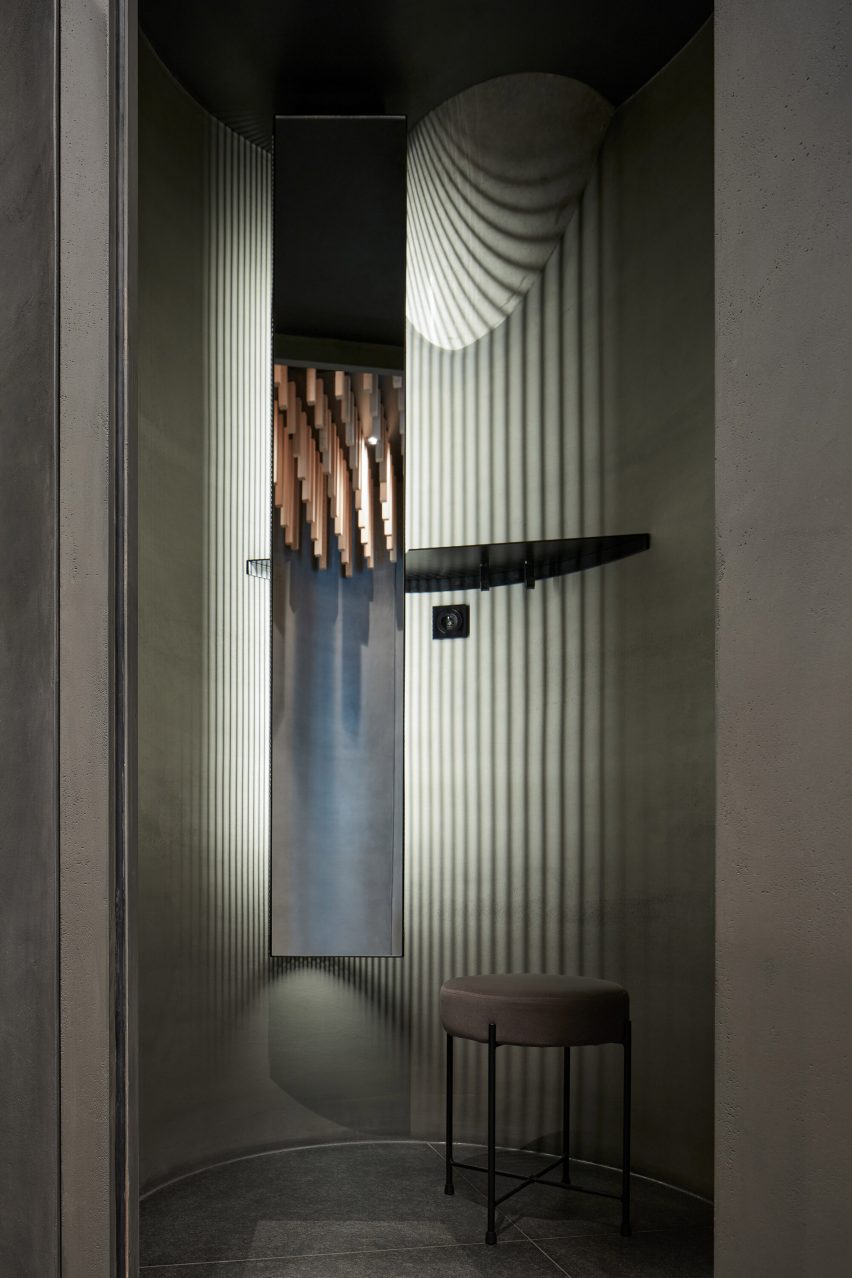 A locker room interior with stool, mirror and dramatic lighting