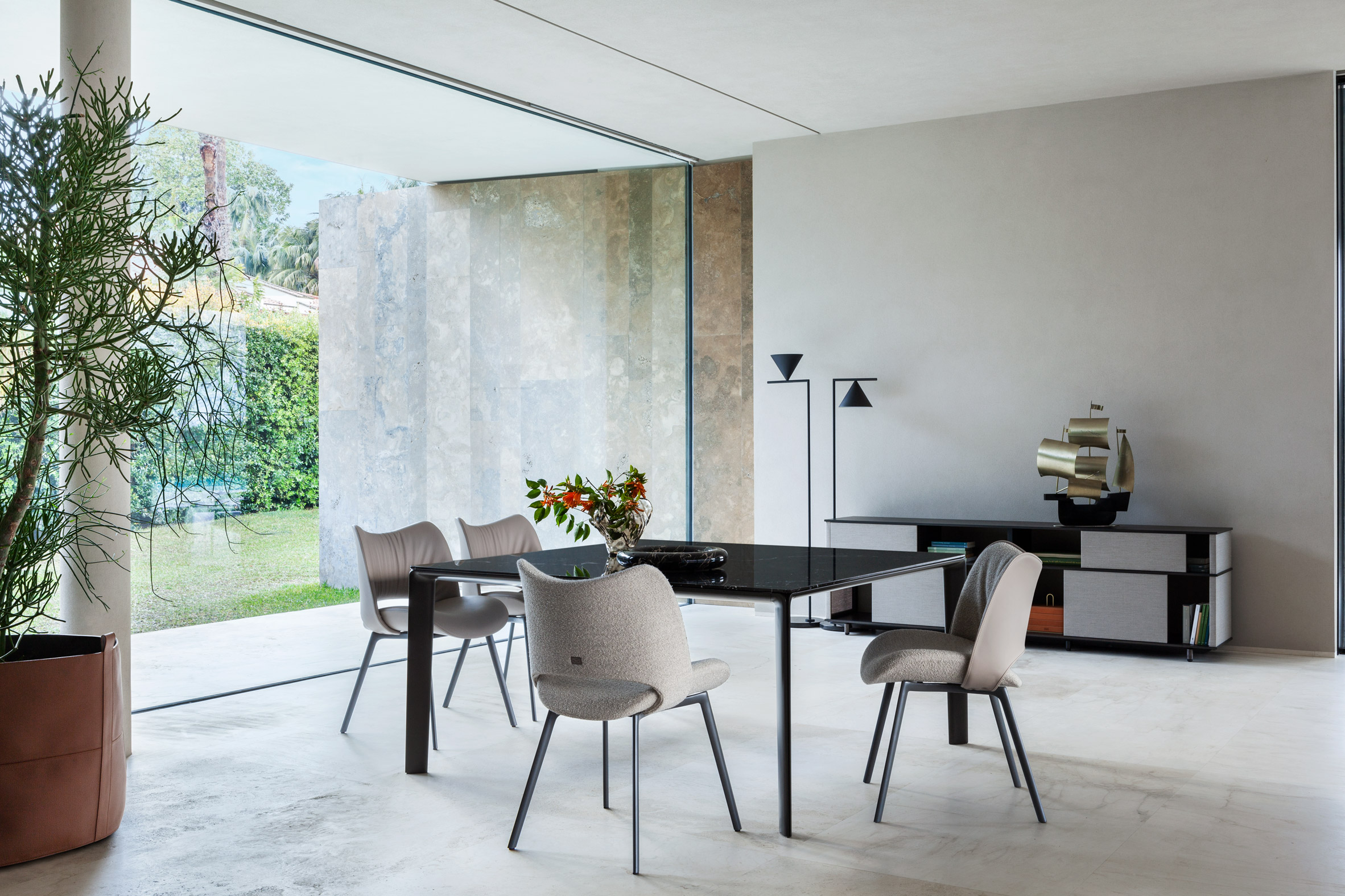 Nice chairs by Poltrona Frau around the Homey table in a concrete room with floor to ceiling glass window