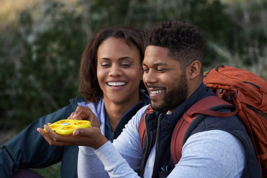 Пара в походе играет с желтым дроном Snapchat