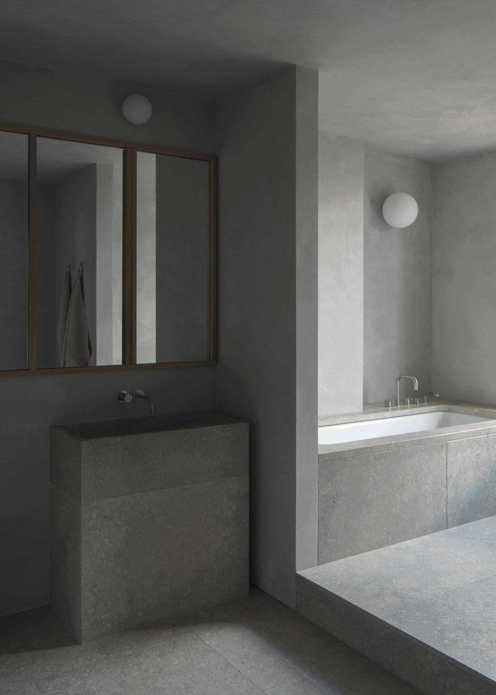Dark bathroom with stone and concrete finishes