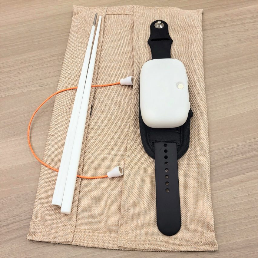 A device that looks like a watch attached to chopsticks