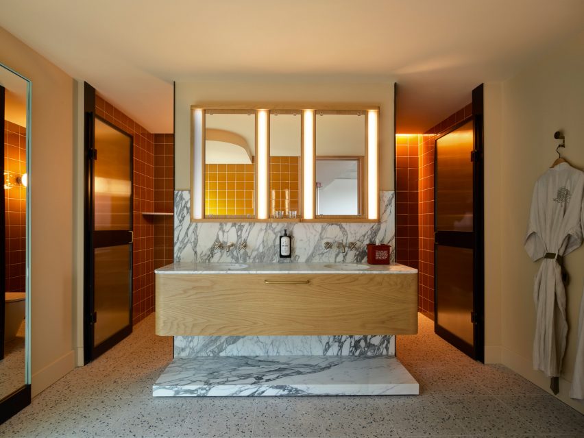 Ванная комната с теплым освещением и мраморными поверхностями в Ace Hotel Sydney
