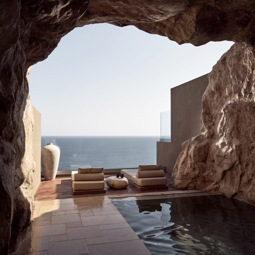Loungers in front of a pool surrounded by cave-like walls in Arco Suites hotel on Crete by Danae and Konstantina Orfanake