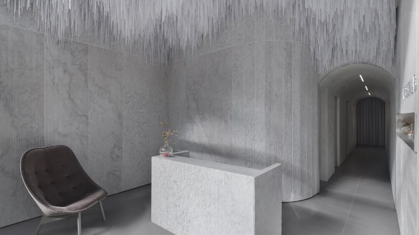 Reception of AER Skinlab in Vancouver by Leckie Studio with marble walls and stalactite-like ceiling installation