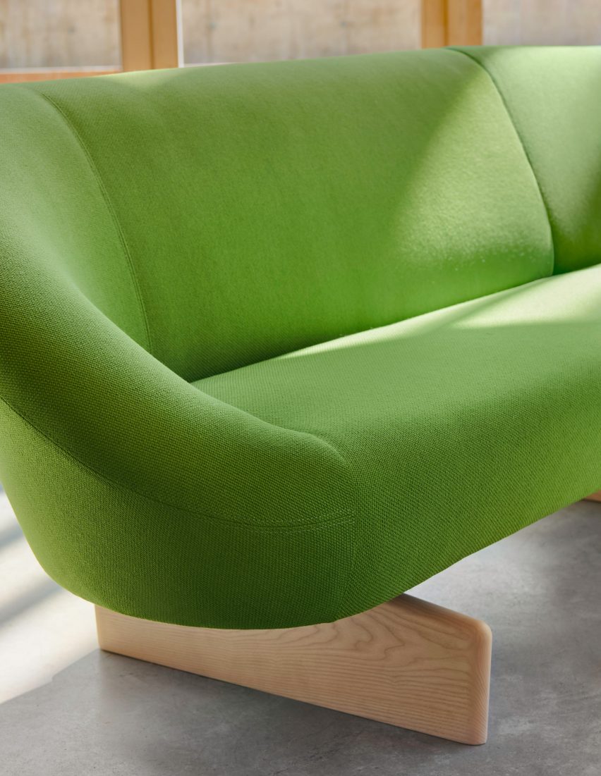 Close-up on swooping armrest and wooden base of the Giro Soft sofa