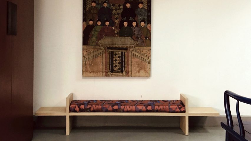 Bench against a wall beneath a large painting