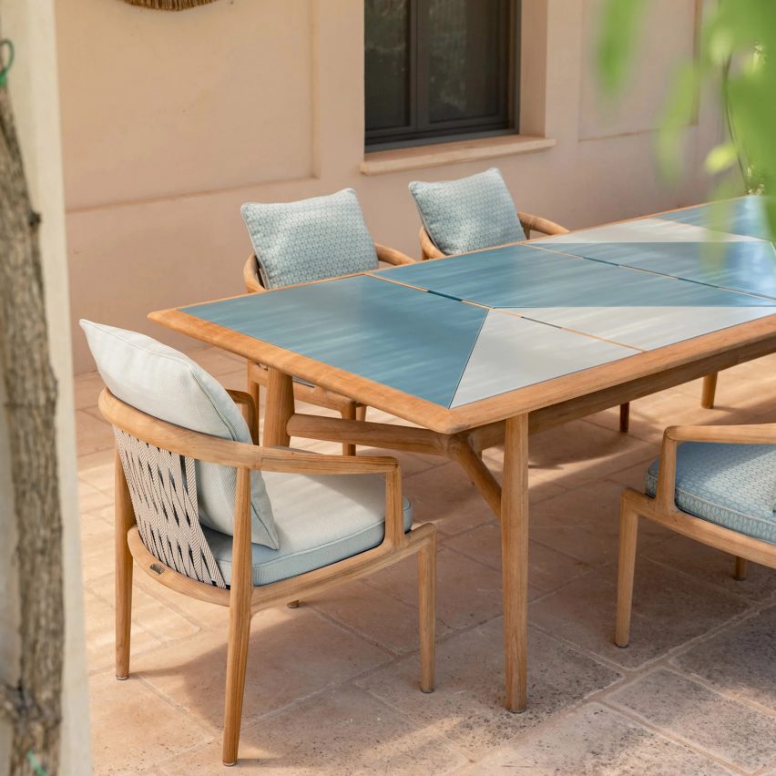 Secret Garden table with blue two-toned top on a patio with dining chairs