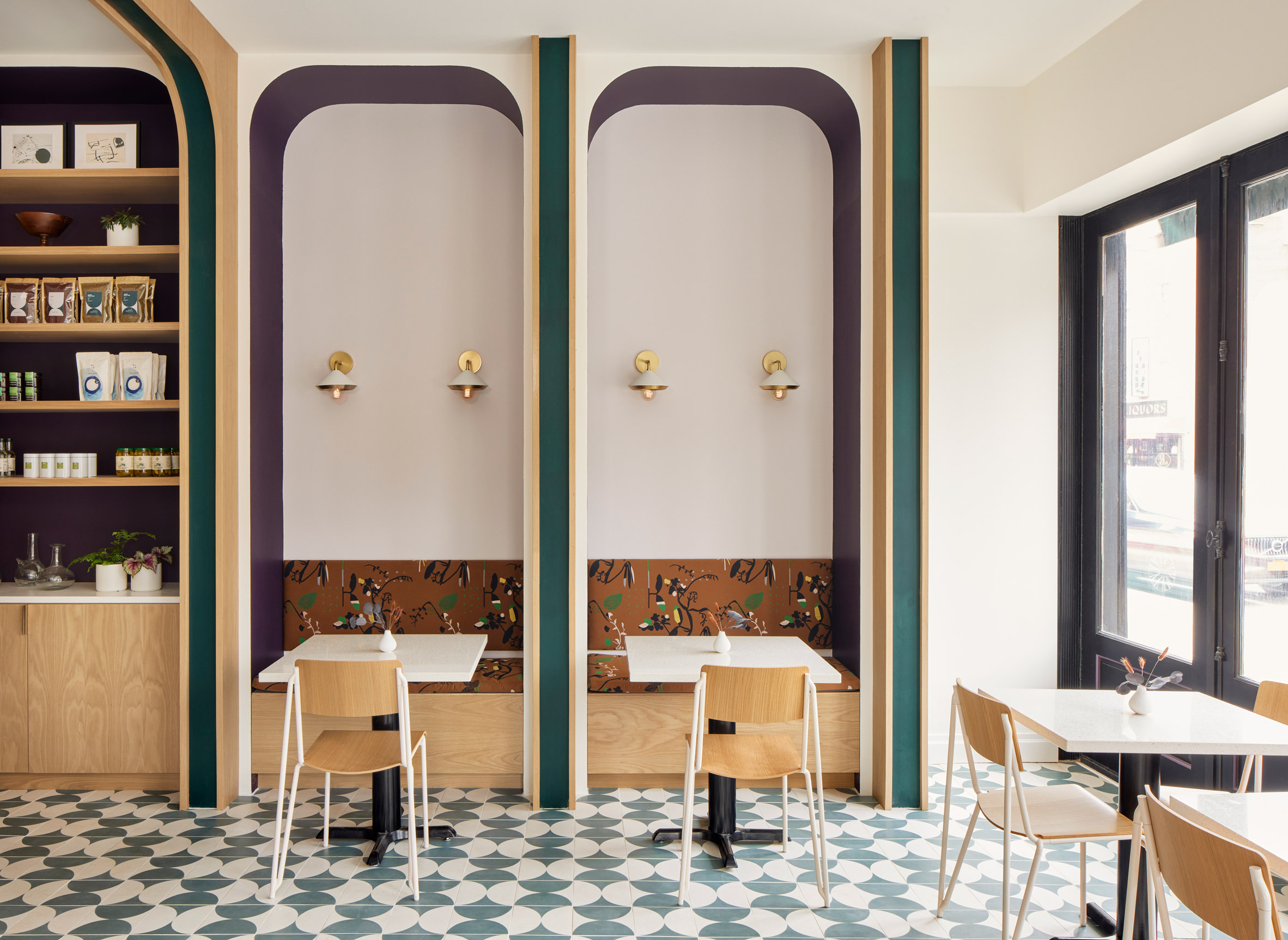 Purple and green accents painted onto walls of patterned restaurant seating booths