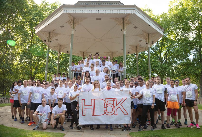 HD5K runners gathered at a band stand with a banner