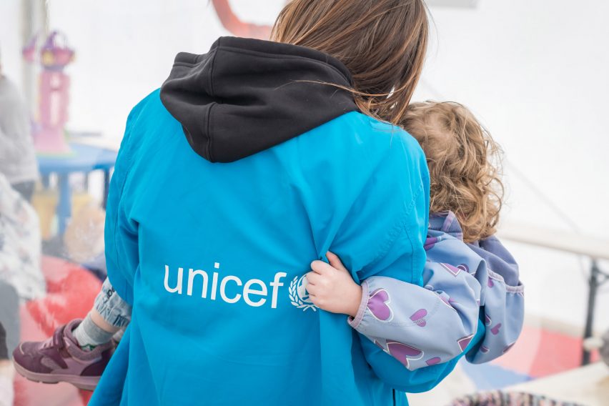 UNICEF volunteer holding a young child