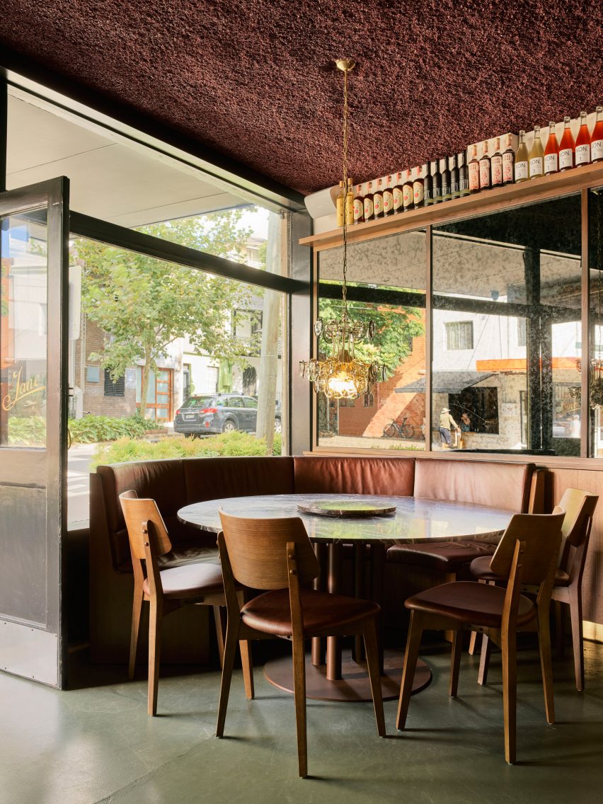 Seating area with stone table and wooden chairs in bar in Surry Hills, Sydney designed by Luchetti Krelle