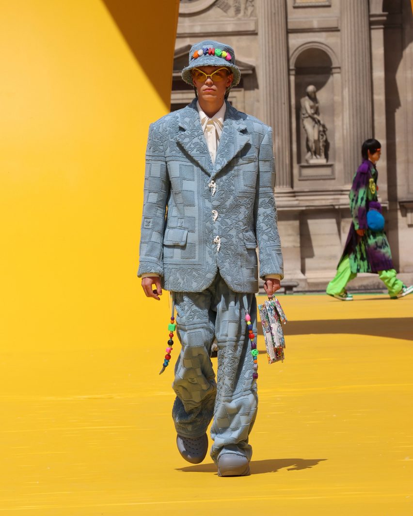 A model is pictured wearing a pale blue suit