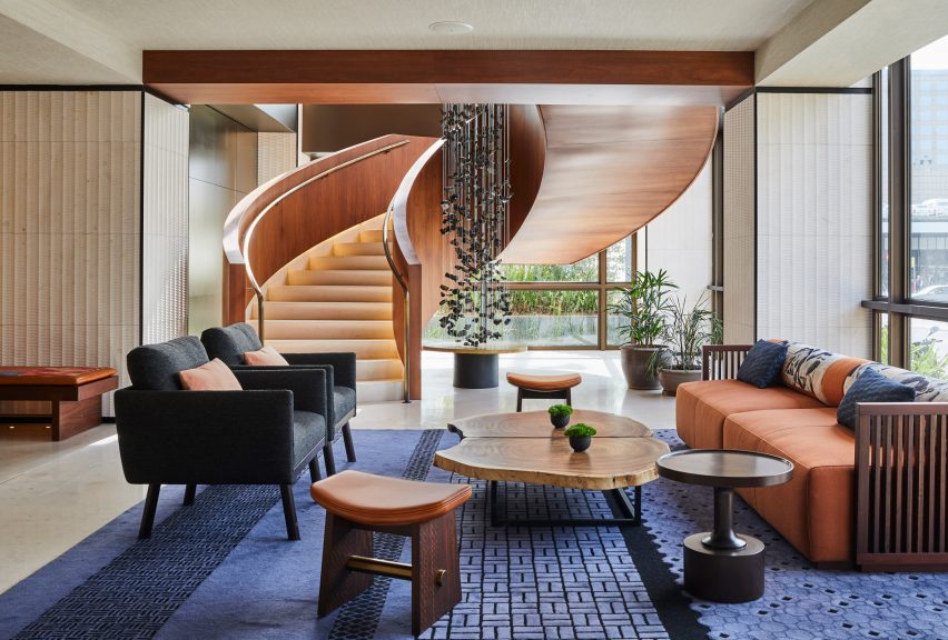 Sofas and armchairs in front of a staircase in the lobby lounge of Nobu Hotel Barcelona