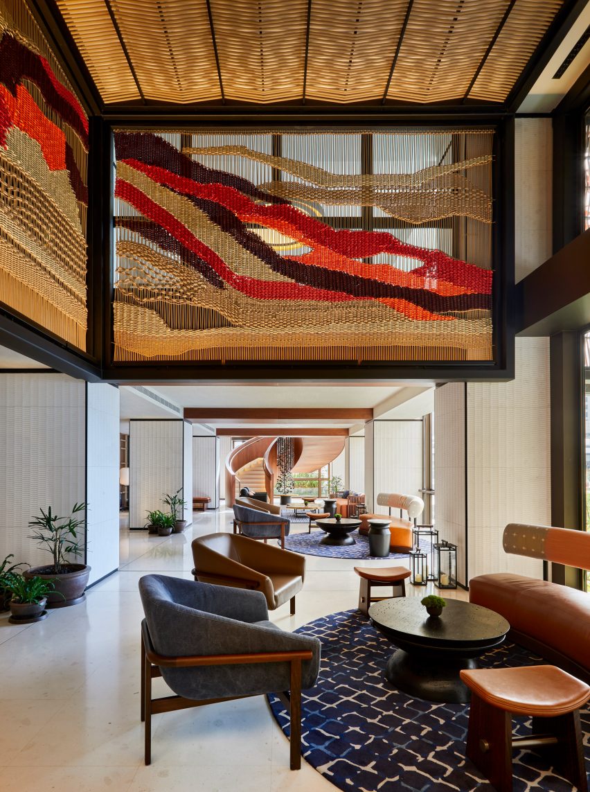 Seating area surrounded by woven screen in hotel lobby by Rockwell Group