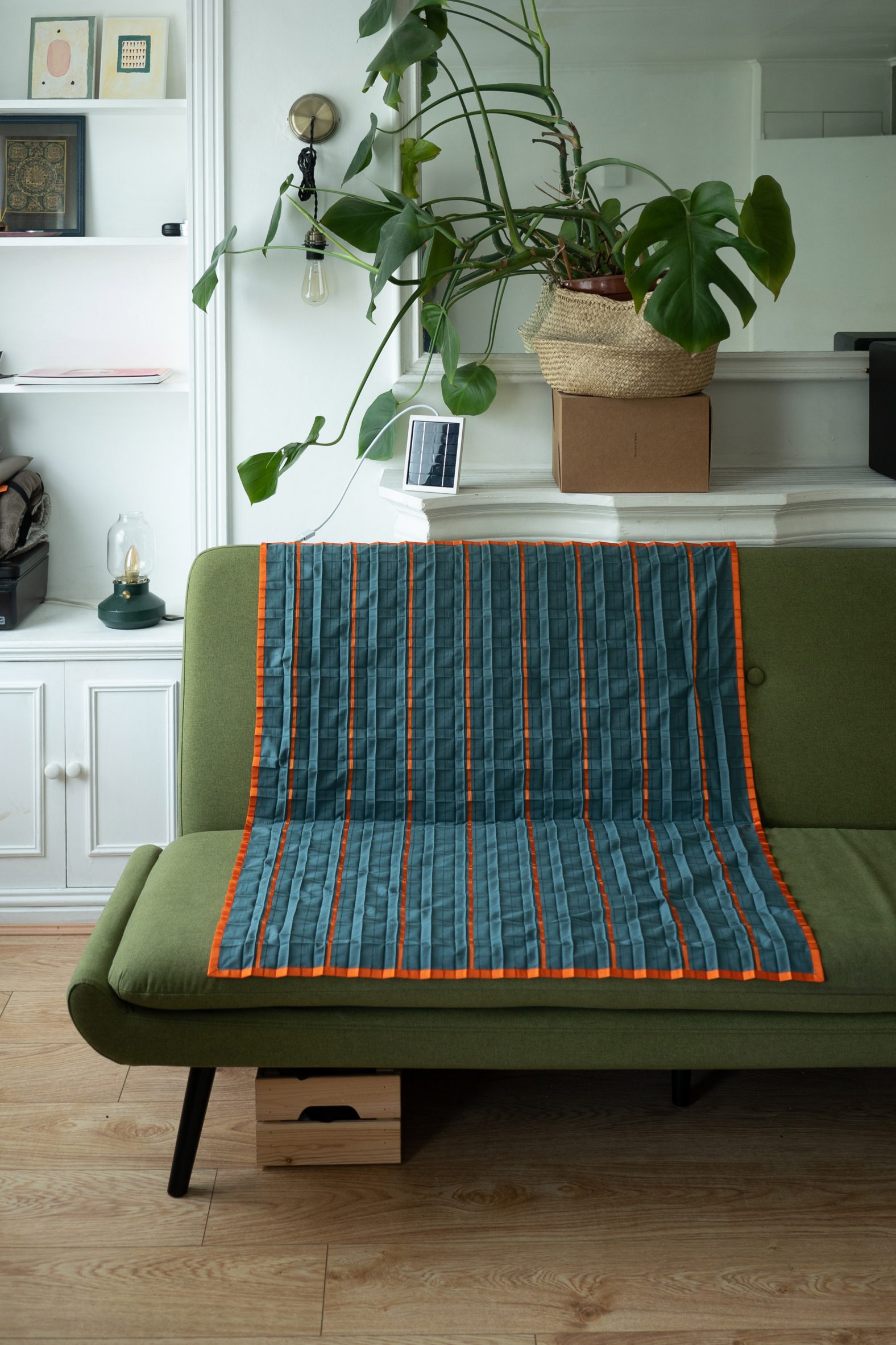 Photo of the Solar Blanket in blue spread on a sofa