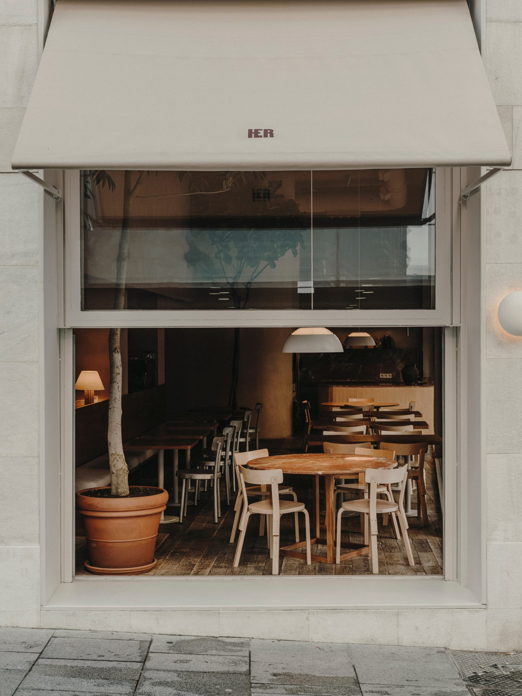 A view into the window of Hermosilla, an earth-toned restaurant in Madrid