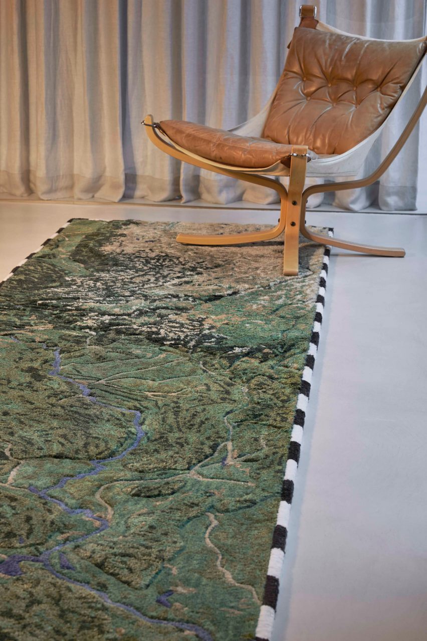 Long Yangtze river rug on floor beneath a leather chair with curtain in the background