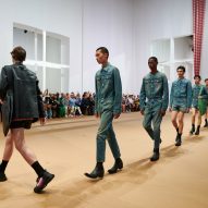 Models are pictured walking across the paper set at the Prada Spring Summer 2023 show