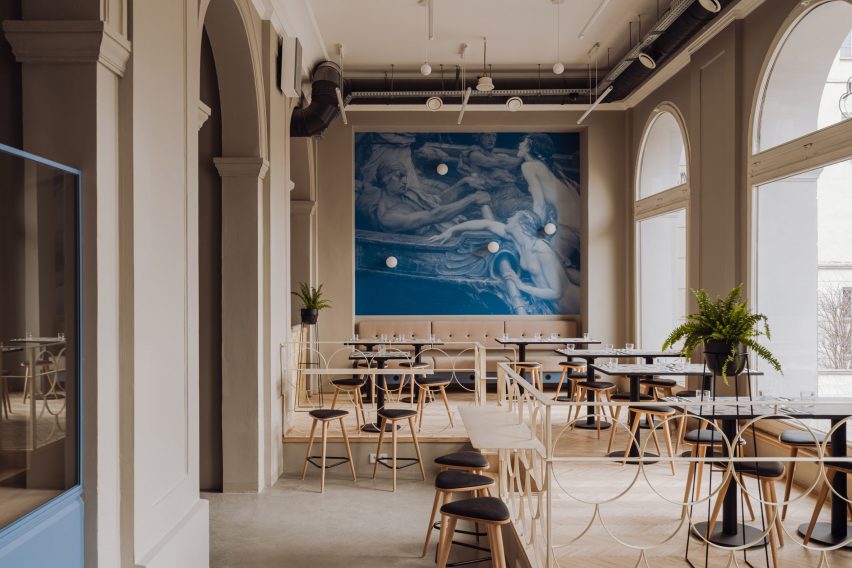 Neutral-toned seating area with blue wallpaper in pierogi restaurant in Warsaw by Projekt Praga