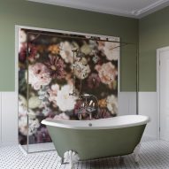 Claw-foot free-standing bath infront of a shower enclosure featuring large-print floral wall covering