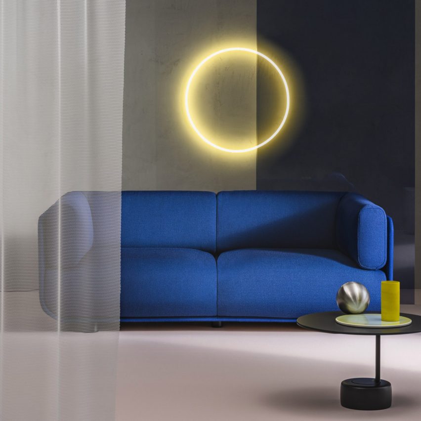 Photograph showing a cobalt blue sofa with yellow ring light behind