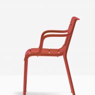 Souvenir armchair in red, side view on white backdrop