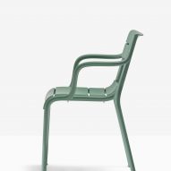 Souvenir armchair in green, side view on white backdrop