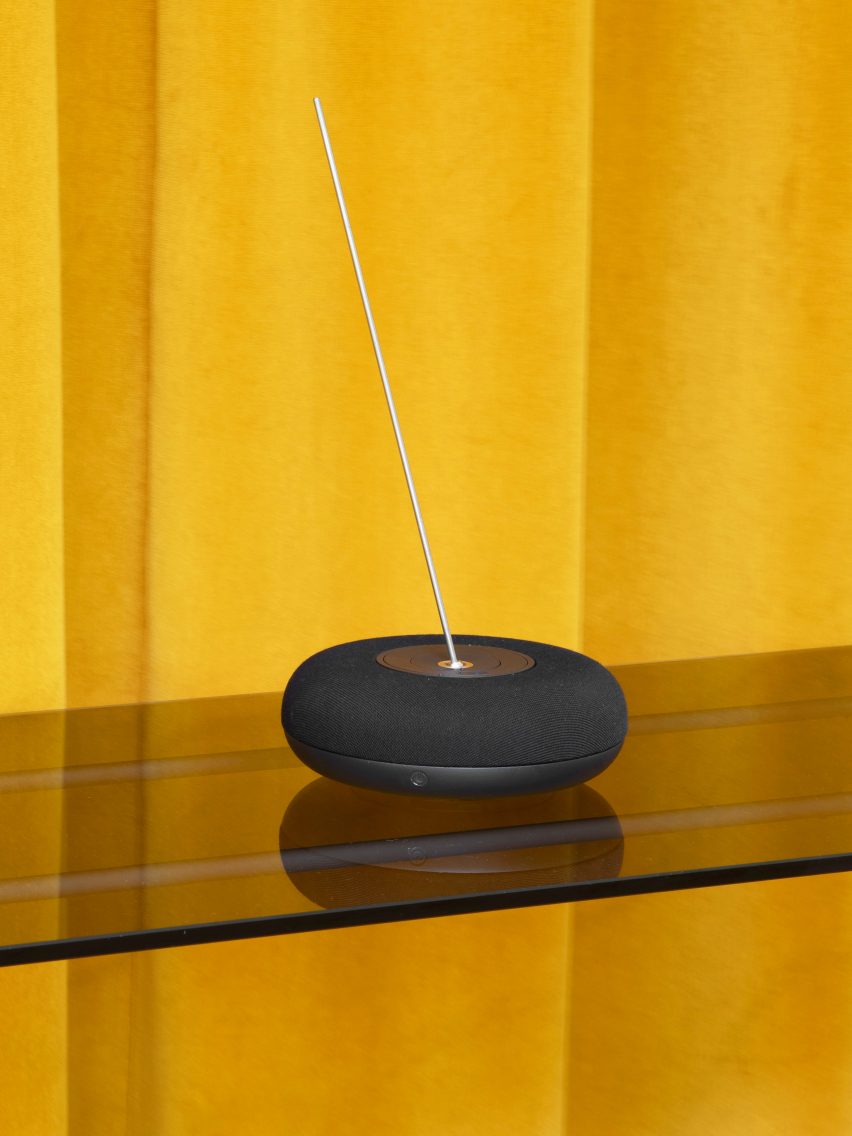 A round music device with a silver antenna attached