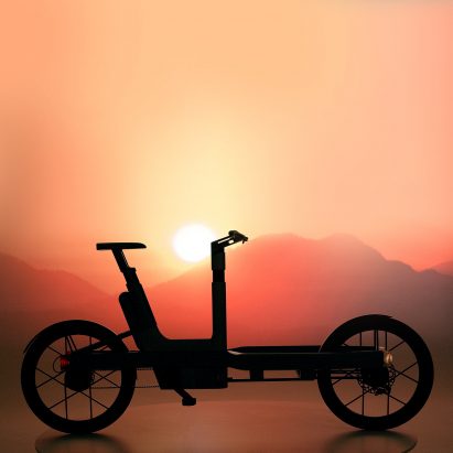 Photograph of a bicycle-style vehicle in front of a sunset