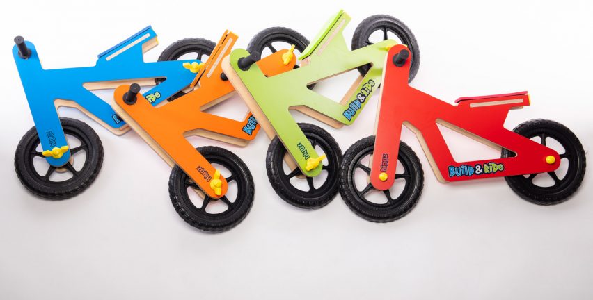 Photograph showing children's toy bikes laying on white backdrop