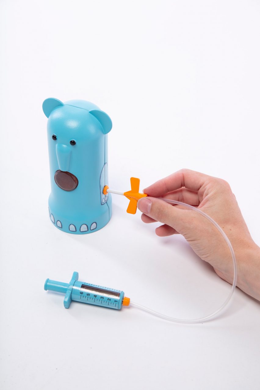 Photo showing a children's toy with pretend syringe, tube and blue bear